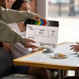 Film crew sets up with a clapperboard on a movie set, capturing a candid moment.